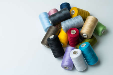 spools of colored sewing thread on white background with copy spaceの写真素材