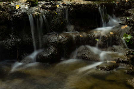 waterfall in a mountain river, silk effect, crystal clear and cool water