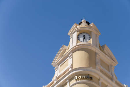 round, malaga, spain, june 28th, 2022 facade of a hotel with a round clock in the background a blue...