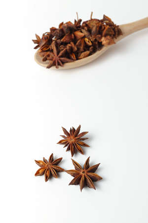 close-up of star anise illicium verum in a wooden spoon isolated on white background and copy spaceの写真素材