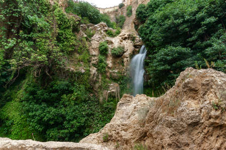 large waterfall over a natural pool for bathing with cold and crystalline water, silk effect, long exposure.の写真素材