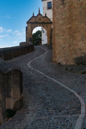 gate or arch of felipe v ronda , malaga old entrance of the city in the background a blue sky with cloudsの写真素材
