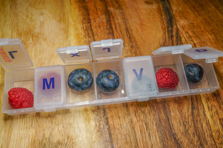 blueberries and raspberries in a pill box drug-free health conceptの写真素材