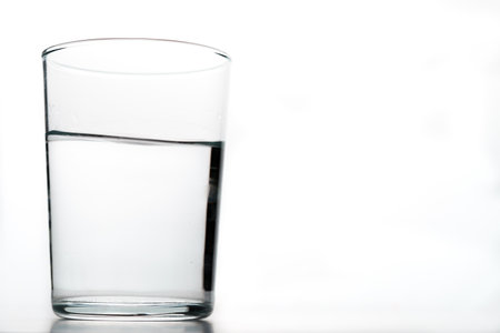 close-up of a moving glass of crystal clear water isolated on a white backgroundの写真素材
