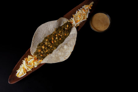 taco with spinach and pine nuts bowl with cheese sauce and various types of cheeses as garnish and...