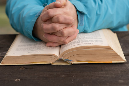 woman with her hands on top of a holy book in prayer pose