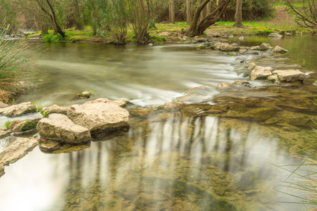 water current in a river, long exposure, reflections of the sun on the waterの写真素材