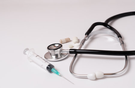 stethoscope, pills and syringe on a doctor's gown on a white background and copy spaceの写真素材
