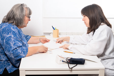 young female doctor explaining to her elderly patient the results of her blood test at the doctor's officeの写真素材