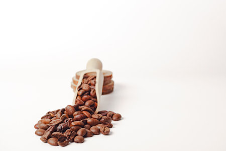 natural roasted coffee beans in a wooden spoon isolated on a white backgroundの写真素材