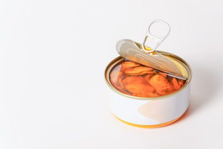 close-up of an open can of mussels in olive oil isolated on a white background