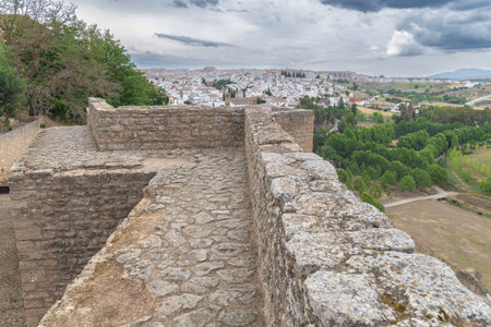 view of the city of ronda from the defensive walls of the city on a day of cloudy stormy skyの写真素材