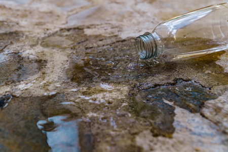 close-up of a plastic water bottle spilling water on a flight of stairsの写真素材