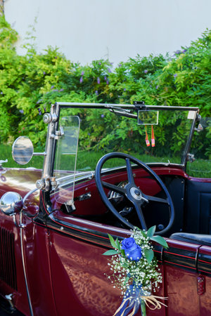 antique Vintage Wedding Car Decorated with Flowers prepared to take the bride and groom to the churchの写真素材