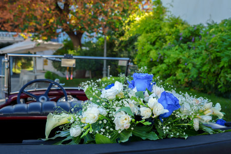 antique Vintage Wedding Car Decorated with Flowers prepared to take the bride and groom to the churchの写真素材
