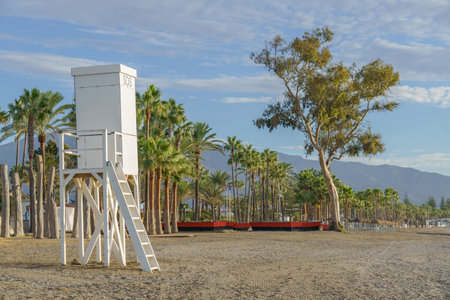 lifeguard's house on the beach at sunrise with palm trees in the background and blue sky with cloudsの写真素材