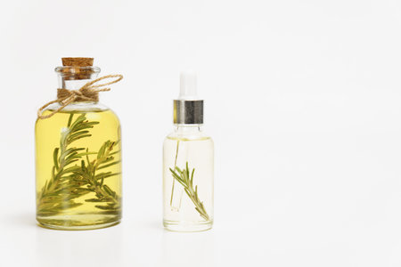 bottle and dropper with rosemary essential oil with fresh branches inside isolated on white background and copy spaceの写真素材