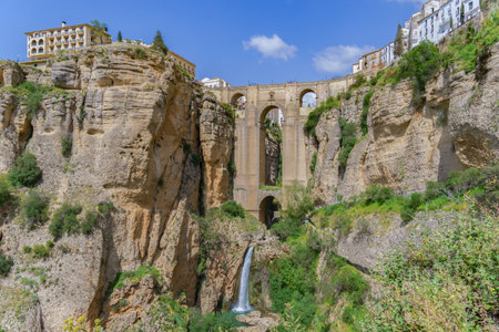 Ronda, Malaga, Spain 04/18/2023 new bridge over the cliff with a waterfall of the river Guadalevinの写真素材