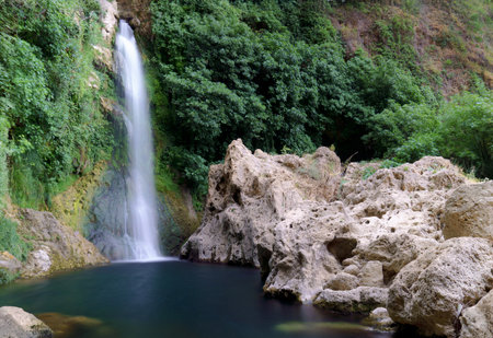 waterfall of a refreshing mountain river with the walls covered with moss and the water long exposure, silk effectの写真素材