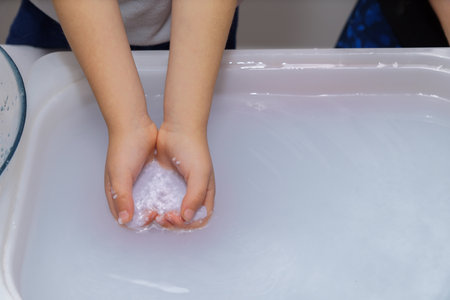 close-up of a child's hands picking up recycled paper pulpの写真素材