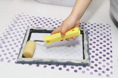 close-up of a child's hands with a rolling pin making eco-friendly recycled paper at homeの写真素材