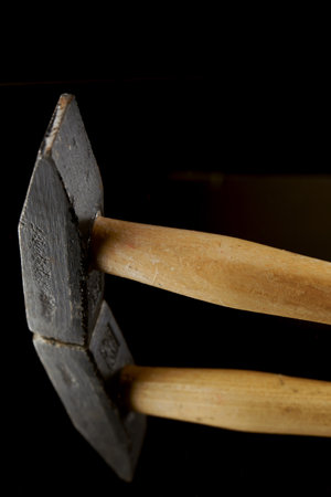close-up of a hammer reflected in a mirror isolated on a black background with copy spaceの写真素材