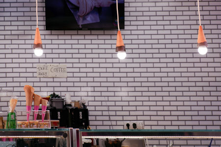 view of an empty cafeteria illuminated by ice cream shaped lamps with a brick wall in the backgroundの写真素材