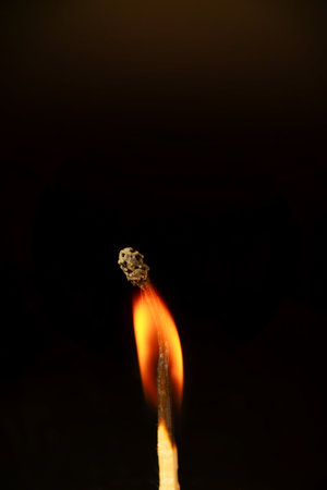 close-up of a burning match isolated on black background with copy spaceの写真素材