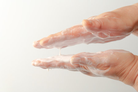 close-up of a woman's hands rubbing a white cream on her handsの写真素材