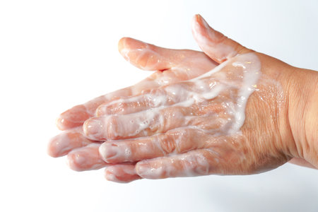 close-up of a woman's hands rubbing a white cream on her handsの写真素材