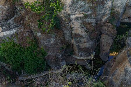 Ronda, Malaga, Spain Breathtaking view of a wooden footbridge navigating a steep, rocky canyon, creating a dramatic and scenic landscapeの写真素材
