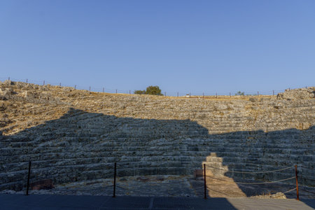 08/21/2025 ronda,malaga,spain Stone steps of a roman theater bask in the sunlight under a vibrant blue sky, showcasing ancient architecture and historical significanceの写真素材