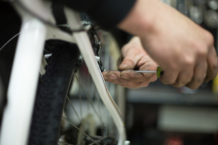 man repairing a bike in his workshopの写真素材
