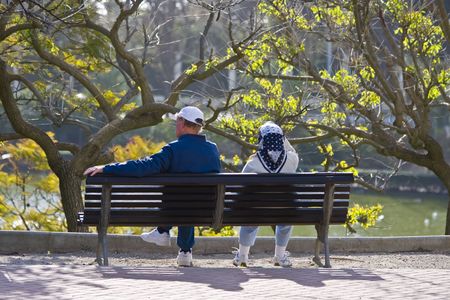 Old couple in sport clothes relaxing in a bench.の写真素材