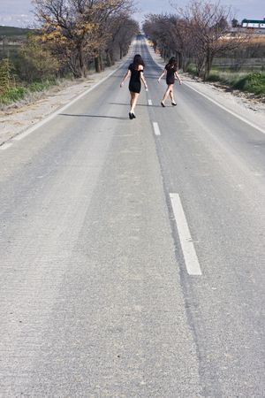 Two young women in the middle of the roadの写真素材