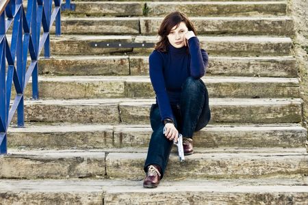 Woman with gun in steps.の写真素材