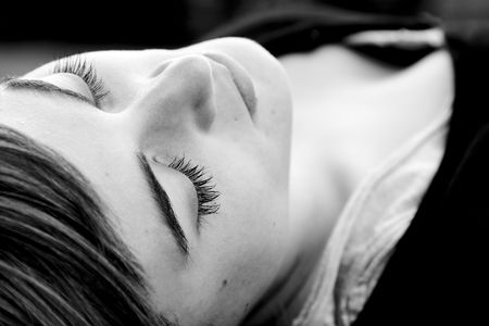 Laying woman with closed eyes, black and white.の写真素材