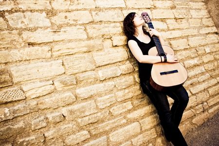 Street artist holding guitar on the wallの写真素材