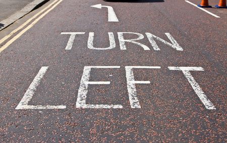 Turn left sign in typical London street asphaltの写真素材