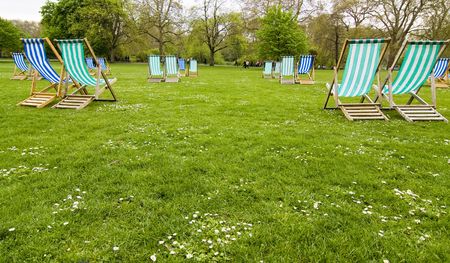 Empty deck chairs in British park.
