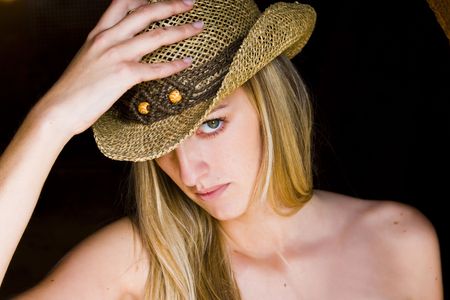 Young blond woman holding her hat.の写真素材