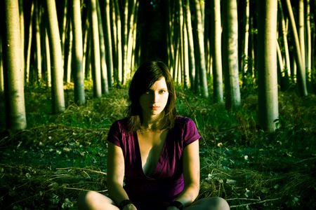 Young woman alone in a dark forest.の写真素材
