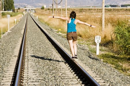 Young woman playing on a railway track.の写真素材