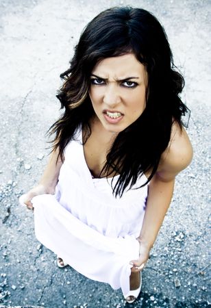 Angry young woman in elegant white dressの写真素材