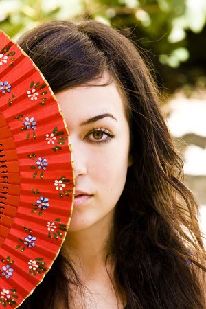 Spanish green eyed woman behind traditional fan.の写真素材