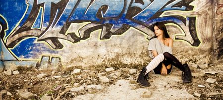 Rebel young girl sat in a dirty place.の写真素材