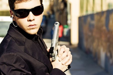 Male model performing secret agent with gun