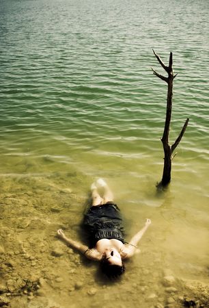 Young woman body over lake waters, closed eyes.の写真素材