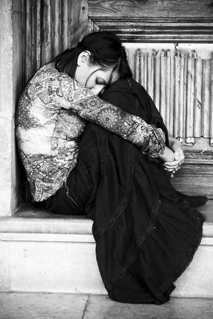 Sad elegant woman sitting and cryingの写真素材