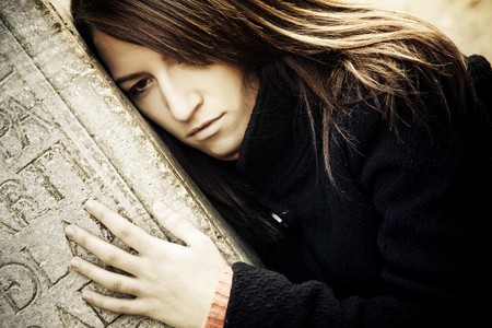 Sad woman embracing a grave.の写真素材